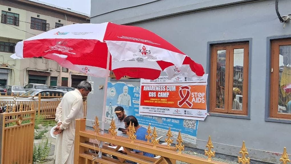 A speaker addressing a gathering at a school beside a KOSHISH drug-free campaign banner